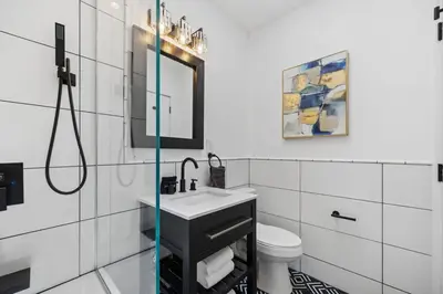 a white bathroom with a sink and a mirror at The Perfect Apt for Large Groups Sleeps 10 in New York