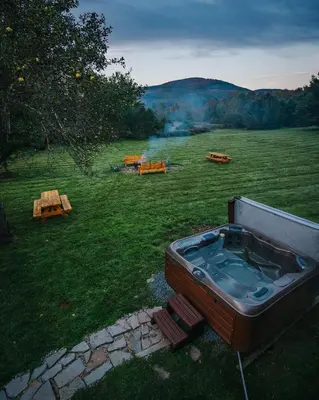 a hot tub in the middle of a field at Idyllic Mountain Stay Hot Tub, Wood Stove, Games in Windham