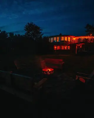 a building with a fire in front of it at night at Idyllic Mountain Stay Hot Tub, Wood Stove, Games in Windham