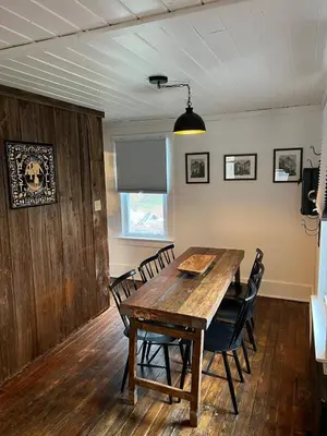 a dining room with a wooden table and chairs at Charming Mtn Stay Views, Hot Tub, Prime Location in West Kill