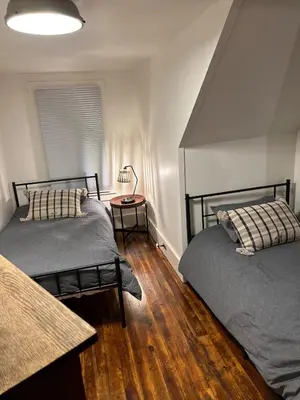 a bedroom with two beds and a table with a lamp at Charming Mtn Stay Views, Hot Tub, Prime Location in West Kill