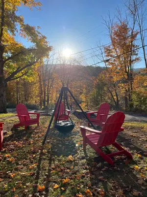 three red chairs and a swing in a park at Charming Mtn Stay Views, Hot Tub, Prime Location in West Kill