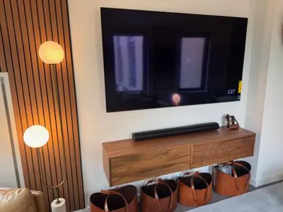 a living room with a television on a wall at NEWLuxe 2bd2ba w Pool & More in Hoboken
