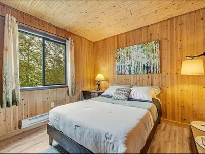 a bedroom with a bed in a wooden room at Cabin Retreat with Hot Tub in Pocono Country Place