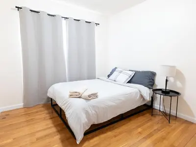a bedroom with a bed with two towels on it at New 4 Apts-198-3 Bed Apt 1st Floor & 3 Bed Apt 2nd Floor - 1 Bed Studio Apt Ground Floor & 1 Bed Studio Apt Ground Floor near Penn Station EWR Newark NJ Airport Hospital Manhattan NYC in Newark