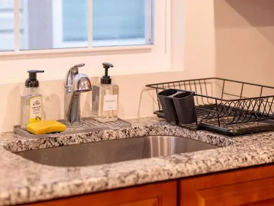 a kitchen counter with a sink and two bottles of soap at New 4 Apts-198-3 Bed Apt 1st Floor & 3 Bed Apt 2nd Floor - 1 Bed Studio Apt Ground Floor & 1 Bed Studio Apt Ground Floor near Penn Station EWR Newark NJ Airport Hospital Manhattan NYC in Newark