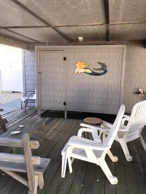 a room with two white chairs and a sign on the wall at Great Value - Oceanside Raised Ranch Location Is Perfect For Walking To Beach, Restaurants, Pizza, Ice Cream Or Coffee 13419 in Upper Greenwood Lake