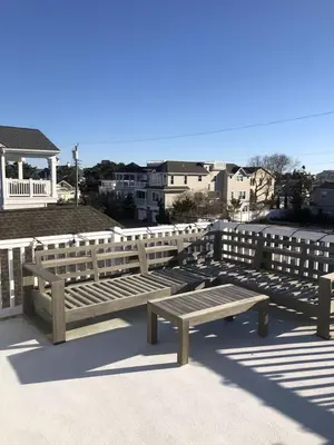 two wooden benches sitting next to a fence at Great Value - Oceanside Raised Ranch Location Is Perfect For Walking To Beach, Restaurants, Pizza, Ice Cream Or Coffee 13419 in Upper Greenwood Lake