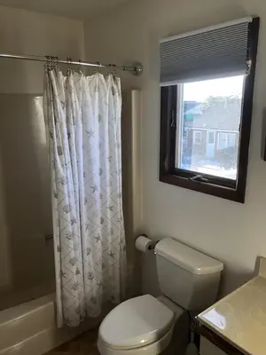 a bathroom with a white toilet and a window at Great Value - Oceanside Raised Ranch Location Is Perfect For Walking To Beach, Restaurants, Pizza, Ice Cream Or Coffee 13419 in Upper Greenwood Lake