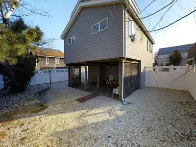 a house with a garage with a fence at Great Value - Oceanside Raised Ranch Location Is Perfect For Walking To Beach, Restaurants, Pizza, Ice Cream Or Coffee 13419 in Upper Greenwood Lake
