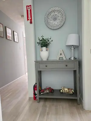 a gray console table with a vase and a lamp at Kaaterskill Waterfall House in Haines Falls