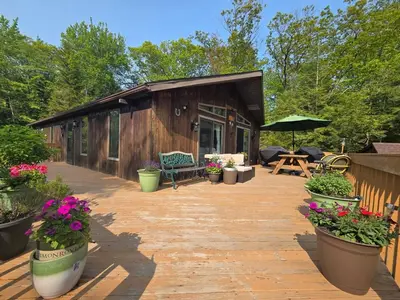 a deck with potted plants in front of a cabin at Kaaterskill Waterfall House in Haines Falls
