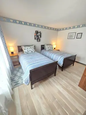 two beds are in a room with wood floors at Kaaterskill Waterfall House in Haines Falls