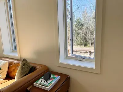 a living room with a couch and a window at Cozy Cabin with Fireplace, Games, Coffee on 5 Acres in Hunter