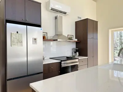 a kitchen with a stainless steel refrigerator and wooden cabinets at Cozy Cabin with Fireplace, Games, Coffee on 5 Acres in Hunter