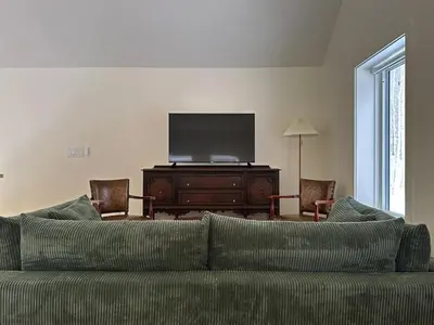 a living room with a couch and a flat screen tv at Cozy Cabin with Fireplace, Games, Coffee on 5 Acres in Hunter