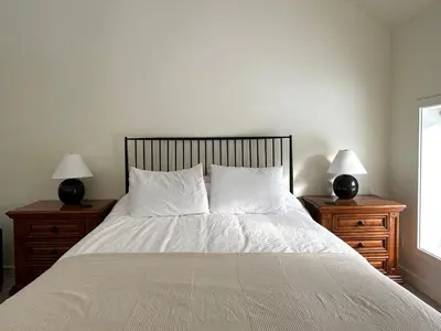 a bedroom with a bed with two nightstands and two lamps at Cozy Cabin with Fireplace, Games, Coffee on 5 Acres in Hunter
