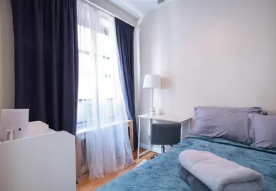 a bedroom with a bed and a large window at 3BR apt two blocks to Central Park elevator, laundry, virtual doorman in New York
