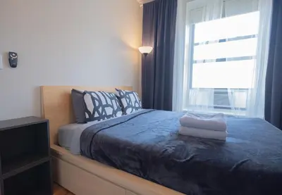 a bedroom with a bed with a blue blanket and a window at 3BR apt two blocks to Central Park elevator, laundry, virtual doorman in New York