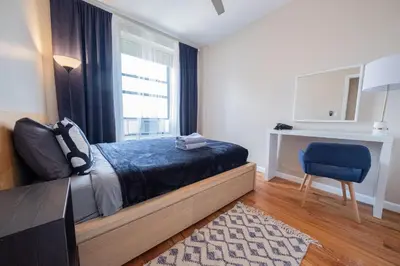 a bedroom with a bed and a window and a chair at 3BR apt two blocks to Central Park elevator, laundry, virtual doorman in New York
