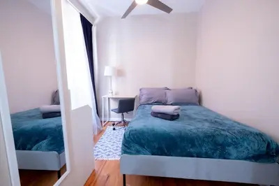a small bedroom with a bed and a mirror at 3BR apt two blocks to Central Park elevator, laundry, virtual doorman in New York