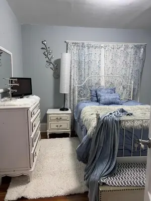 a bedroom with a bed and a dresser and a lamp at Eden's Lodge in East Hartford