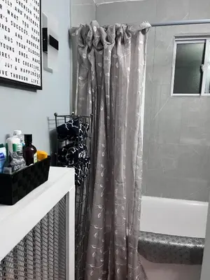 a shower curtain in a bathroom next to a tub at Eden's Lodge in East Hartford