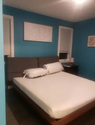 a bedroom with a large bed with a blue wall at Comfy 3 bedroom house in Newark