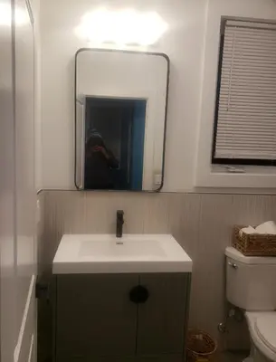 a person taking a picture of a bathroom with a sink at Comfy 3 bedroom house in Newark
