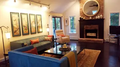 a living room with a blue couch and a fireplace at The Woodridge Retreat in Goshen