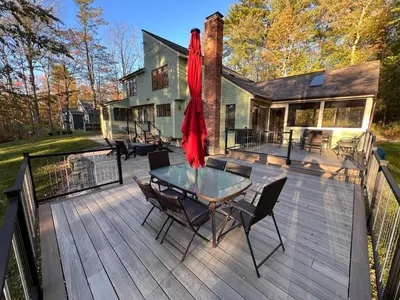 a wooden deck with a table and chairs on it at The Woodridge Retreat in Goshen