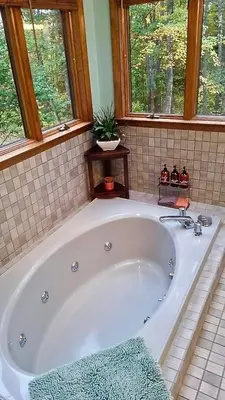 a large white bath tub in a bathroom with windows at The Woodridge Retreat in Goshen