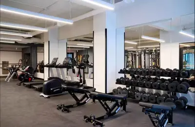 a gym with lots of treadmills and weights at NEW Chic & Cozy 1BD Apartment Near East River, Minutes from Central Park in New York