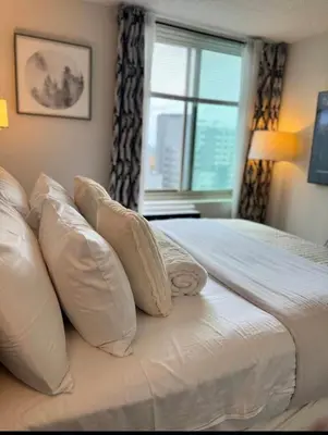 a bedroom with a bed with pillows and a window at NEW Chic & Cozy 1BD Apartment Near East River, Minutes from Central Park in New York