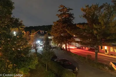 a city street at night with cars parked on the street at Croton Quarters - Comfortable Apartments, NYC close in Croton-on-Hudson