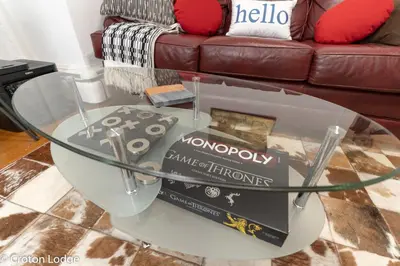 a book sitting on a glass table in a living room at Croton Quarters - Comfortable Apartments, NYC close in Croton-on-Hudson