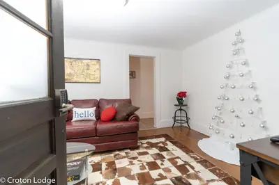 a living room with a christmas tree and a couch at Croton Quarters - Comfortable Apartments, NYC close in Croton-on-Hudson