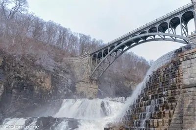 a bridge over a waterfall with a waterfall at Croton Quarters - Comfortable Apartments, NYC close in Croton-on-Hudson