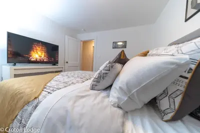 a bedroom with a bed with a fire in the fireplace at Croton Quarters - Comfortable Apartments, NYC close in Croton-on-Hudson
