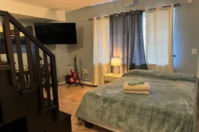 a bedroom with a bed and a flat screen tv at NY - NJ Tennis Suites - Sleeps 40 - 15 Mins to NYC in Union City