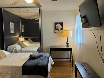 a bedroom with two beds and a mirror at NY - NJ Tennis Suites - Sleeps 40 - 15 Mins to NYC in Union City
