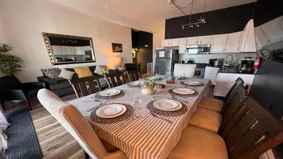 a dining room table with chairs and a kitchen at Max NY VIEW 5 Apartment Combo Sleeps 60 15 Mins to NYC in Union City