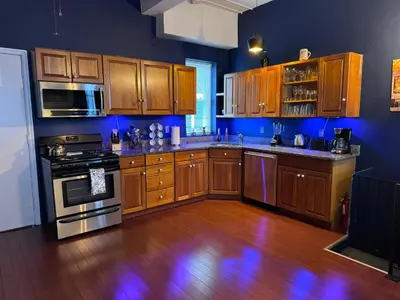 a kitchen with wooden cabinets and a wooden floor at Triple See NY Now - Sleeps 41 -15 Mins to NYC in Union City