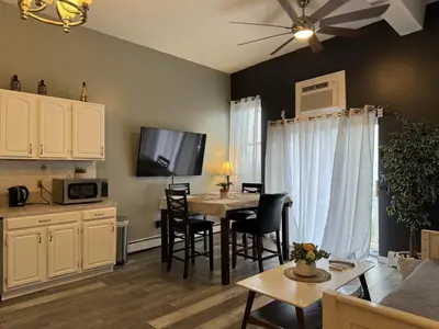 a kitchen and living room with a table and chairs at Triple See NY Now - Sleeps 41 -15 Mins to NYC in Union City