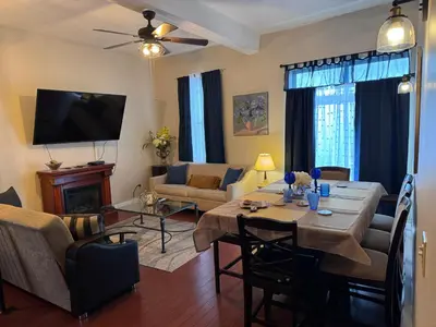 a living room with a table and a couch and a television at Mega Trade Stunning View - APT 3-4 Combination in Union City