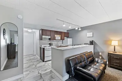a living room with a couch and a kitchen at Chic New York Studio with Kitchen in Hyde Park