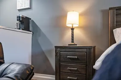 a lamp on a dresser next to a bed at Chic New York Studio with Kitchen in Hyde Park