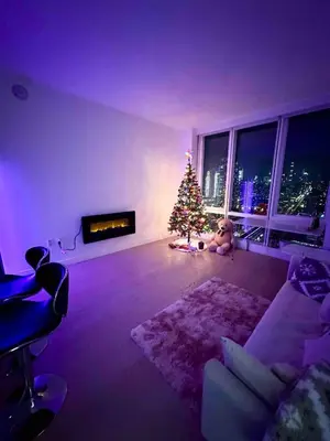 a living room with a christmas tree in front of a window at 1 Stop to Midtown Amazing View Luxury High Rise Corner 1 Bedroom Apartment in Sunnyside
