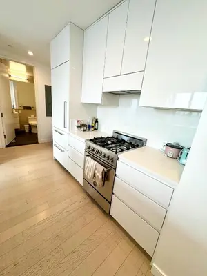 a kitchen with white cabinets and a stove at 1 Stop to Midtown Amazing View Luxury High Rise Corner 1 Bedroom Apartment in Sunnyside