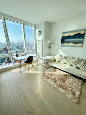 a living room with a couch and a table and windows at 1 Stop to Midtown Amazing View Luxury High Rise Corner 1 Bedroom Apartment in Sunnyside